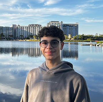 Will standing in front of a lake at Disney World in Florida